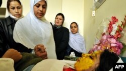 Schoolgirls talk with 17-year-old Shamsia, who was the victim of an acid attack in Afghanistan in 2008, as she rests on a hospital bed in Kabul.