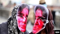 Afghan women in Kabul in March 2016 wear masks depicting Farkhunda Malikzada, who was killed by a mob a year earlier.