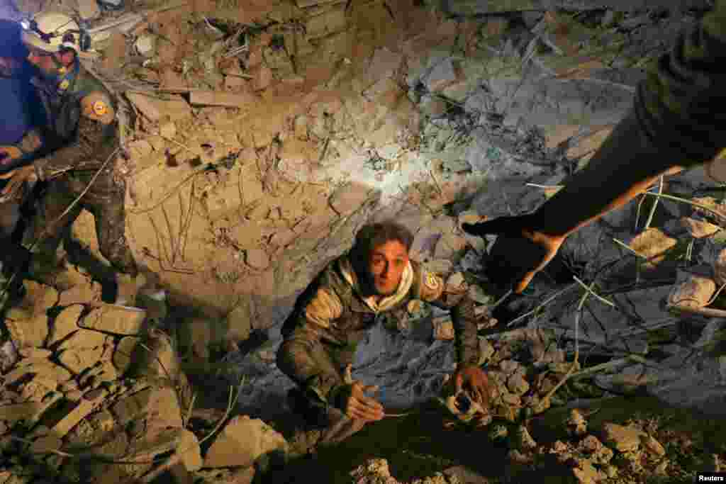 A civil defense member attempts to get out of a site hit at night by an air strike in Saraqeb in the rebel-held province of Idlib in Syria. (Reuters/Ammar Abdullah)