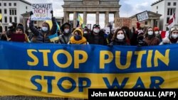 Demonstrators display a placards criticising Russian President Vladimir Putin during a protest in Berlin (file photo)