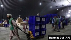 Afghan election workers transport ballot boxes on a trolley to be loaded on trucks for distribution ahead of parliamentary elections scheduled for October 20.