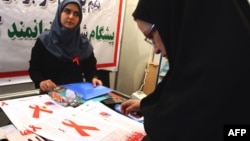 A woman reads a leaflet at an exhibition marking World AIDS Day in Tehran in 2008. Activists are concerned that the calendar change will mean even less public attention paid to an issue that is already a social taboo in Iran.