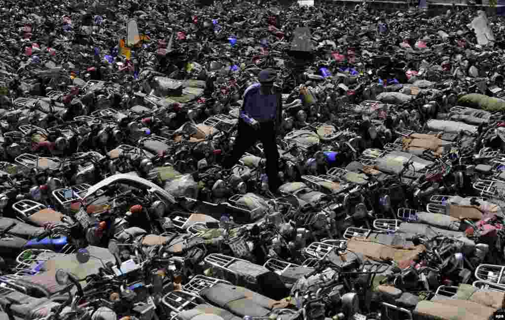 A Yemeni police officer inspects hundreds of seized motorbikes at a police yard in Sanaa. Reports state that Yemeni authorities resumed enforcing a ban on motorbikes used as taxis in Sanaa to prevent Al-Qaeda-linked attacks by motorcyclists on the country's military and security personnel and members of the Shi'ite Houthi movement. (epa/Yahya Arhab)