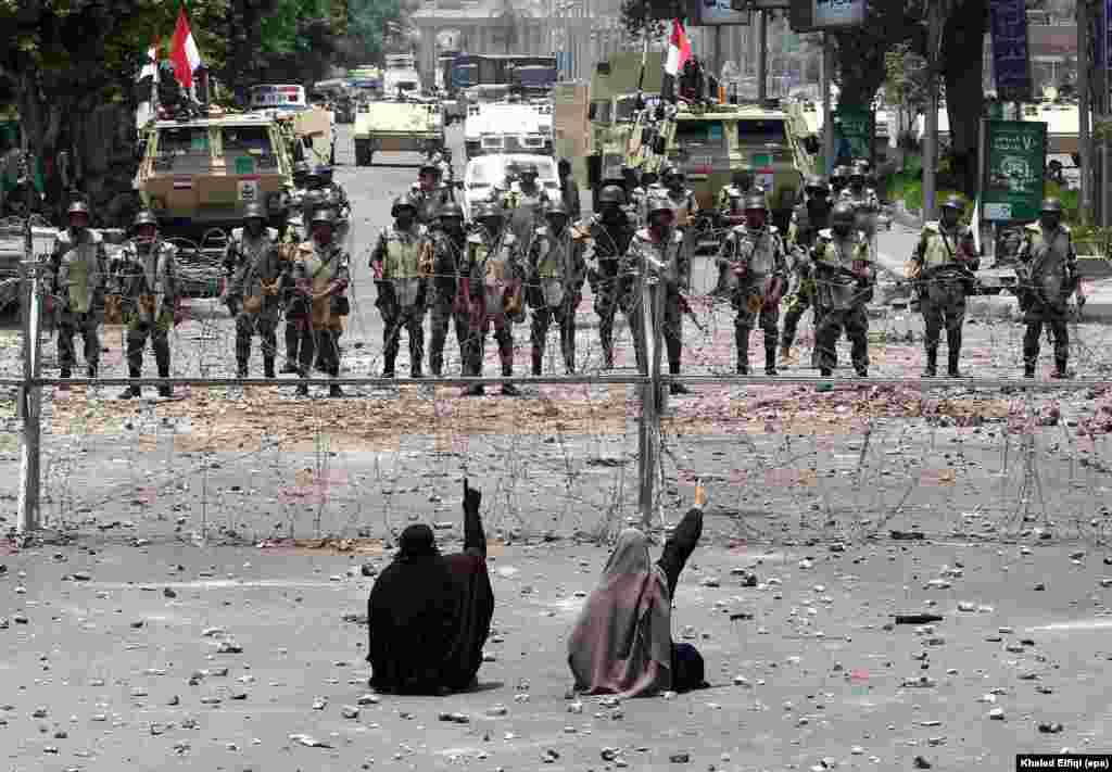 Two supporters of the Muslim Brotherhood face off with soldiers across a barbed wire fence in Cairo, Egypt, on July 8, amid continuing civil unrest five days after the military ousted former President Muhammad Morsi.