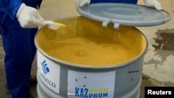 Employees check a barrel filled with yellowcake at Inkai uranium mine near Taikonur, Kazakhstan, in this June 5, 2010 file photo.