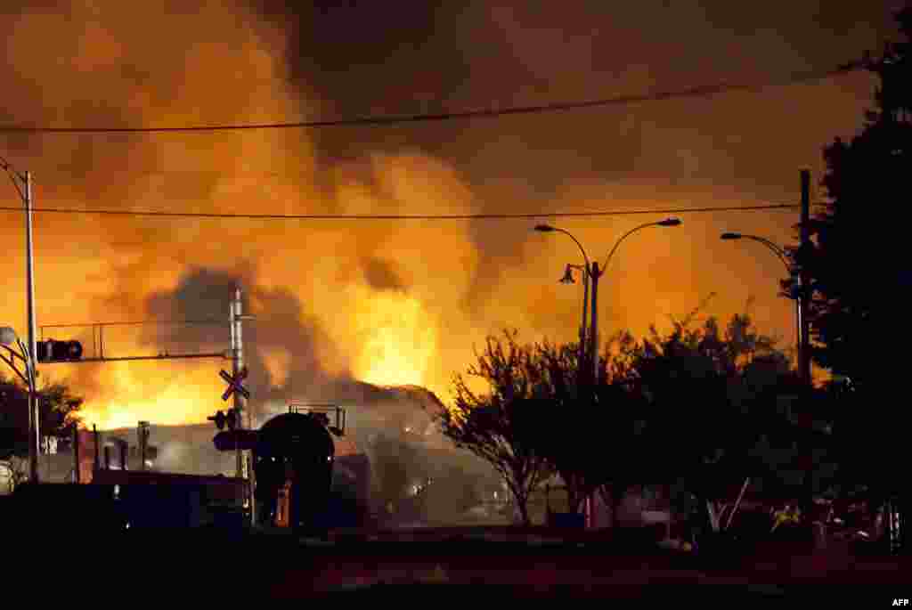 Firefighters douse blazes after a freight train loaded with oil derailed in Lac-Megantic in Canada&#39;s Quebec province, sparking explosions that engulfed about 30 buildings in fire. (AFP/François Laplante-Delagrave)