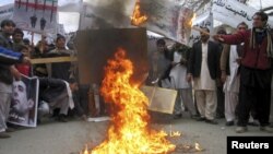 Afghans protesters burn posters of Iran's leaders during a demonstration in Jalalabad Province.
