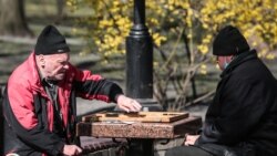Чоловіки грають в шахи на свіжому повітрі в київському парку. 4 квітня 2020 року