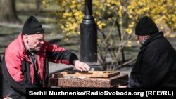 Чоловіки грають в шахи на свіжому повітрі в київському парку. 4 квітня 2020 року