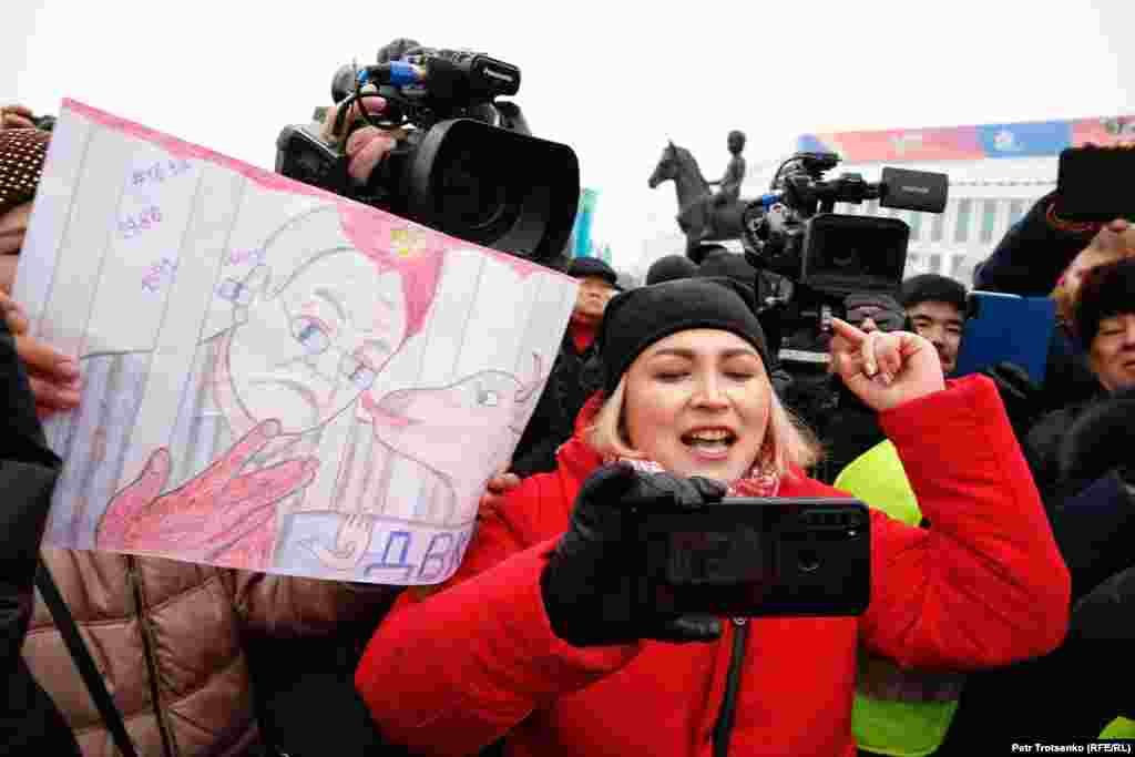 A young woman is surrounded by television camera during the protest. 