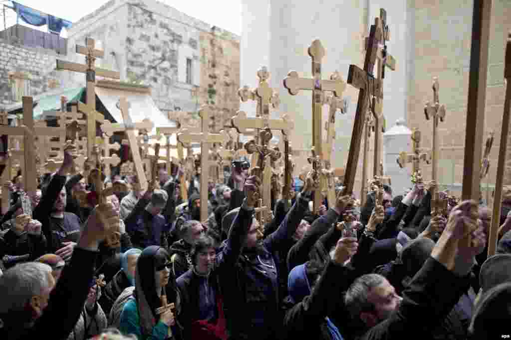 Orthodox Christian worshippers hold crosses and walk outside the church of the Holy Sepulchre during the Good Friday procession in the Old City of Jerusalem on April 10. (epa/Abir Sultan)