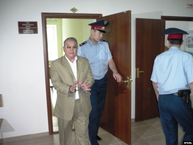 Полицейские выводят бывшего советника акима Западно-Казахстанской области Алпамыса Бектурганова в наручниках из зала суда. Уральск, 13 августа 2009 года.