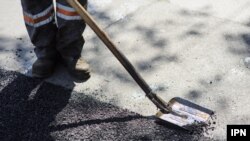 Muncitor care repară drumurile în Chișinău