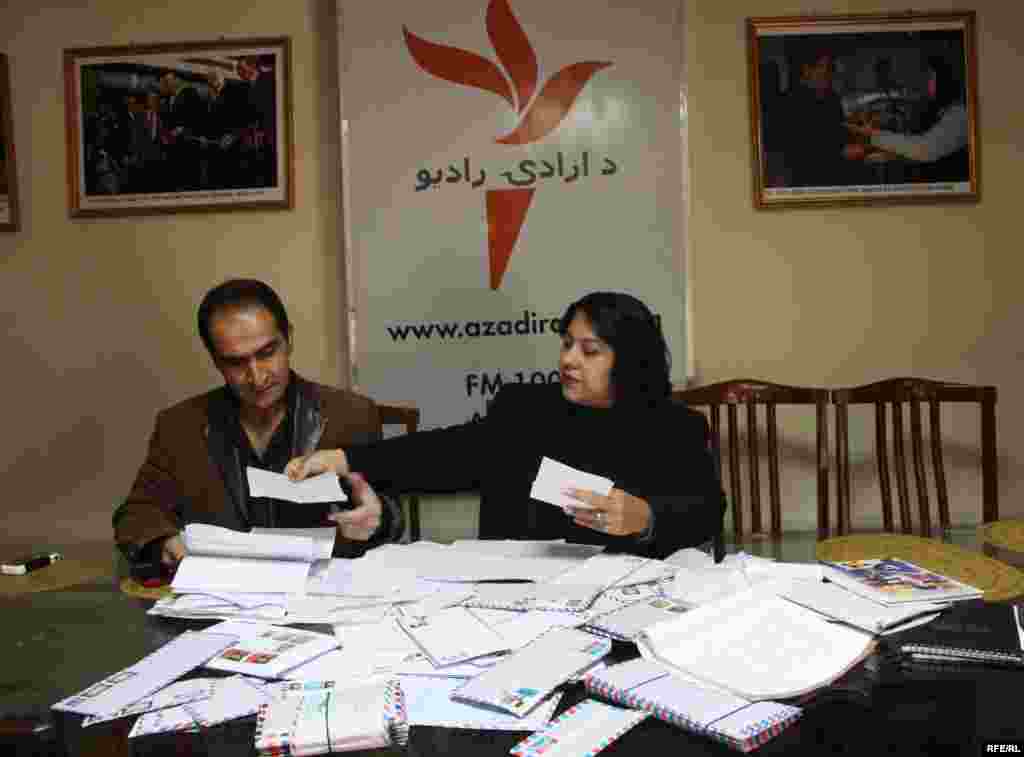 Radio Azadi employees look at letters sent in to the radio station by Afghan listeners