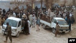 افغانستان: د کندهار په الکوزي کلي کې کلیوال د پېښې قربانیان له خپلو کورونو هدیرې ته وړي. ۱۱م مارچ ۲۰۱۲م کال
