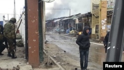 People stand near a burnt market in the Chechen capital, Grozny, in the aftermath of the fighting.