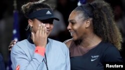 Naomi Osaka me lot në sy derisa Serena Williams e përgëzon për fitore në finalen e US Open.