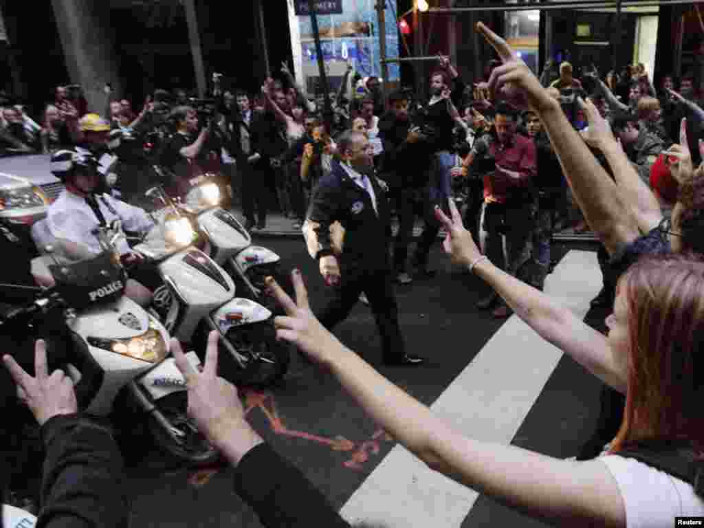 U.S. - New York Police Department officers on motor scooters confront members of the Occupy Wall Street movement during a march through the financial district of New York, 14Oct2011