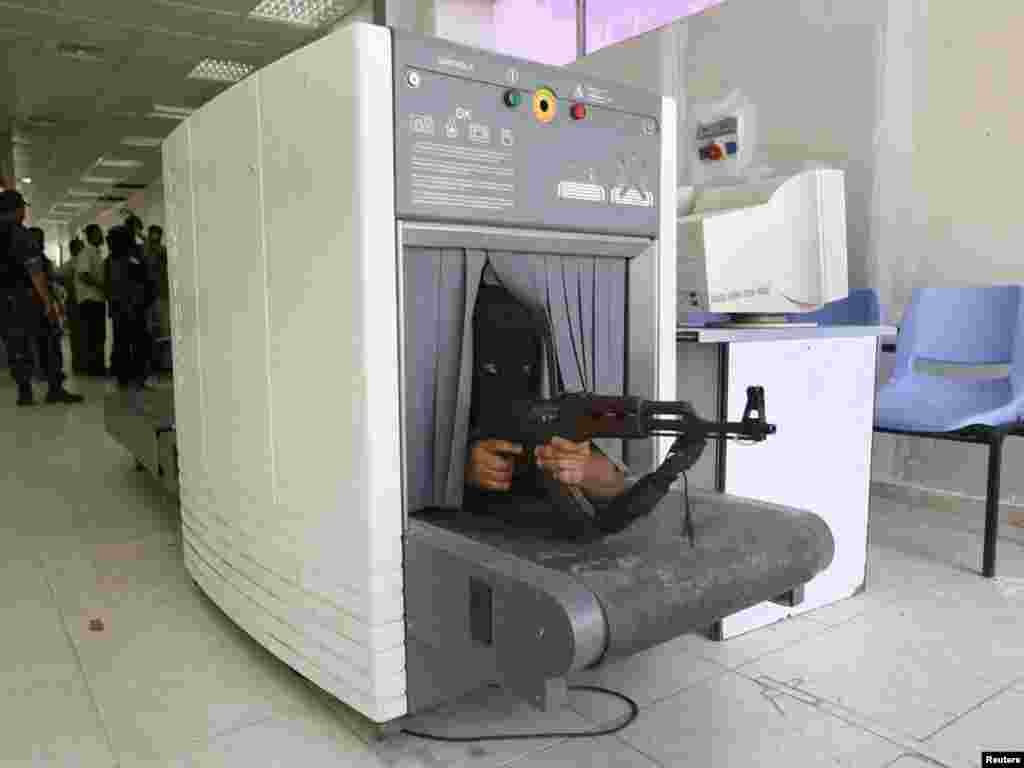 A Hamas fighter takes position inside a scanning machine in the customs hall of the Rafah crossing border, between Egypt and the southern Gaza Strip, after they captured it, June 15, 2007. REUTERS/Ibraheem Abu Mustafa 