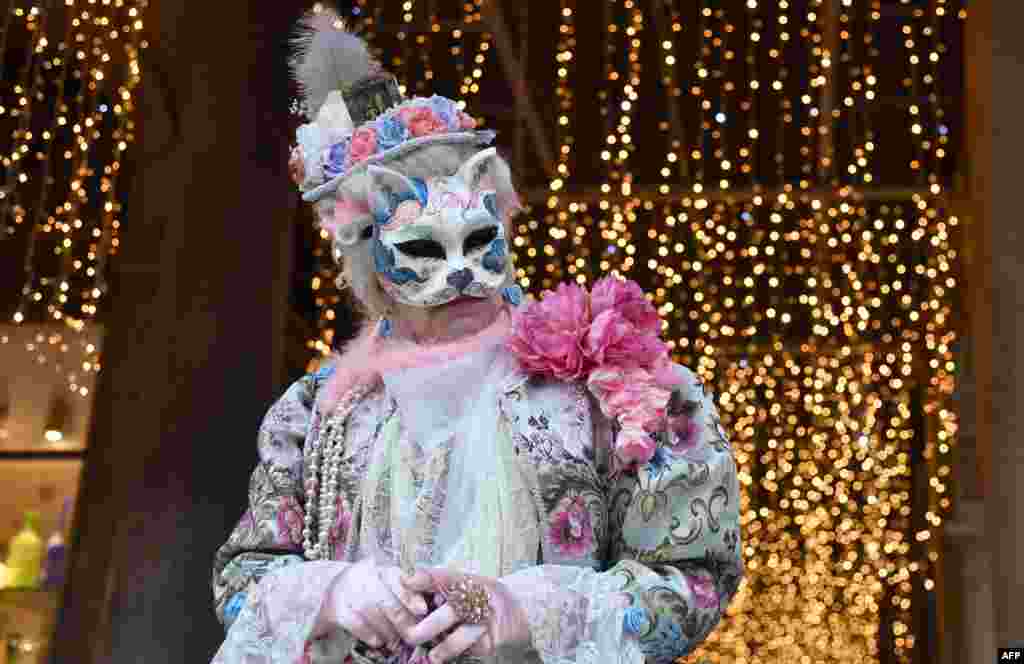 A masked person wearing a traditional carnival costume poses in St. Mark Square in Venice during Venice&#39;s Carnival on February 4. (AFP/Tiziana Fabi)