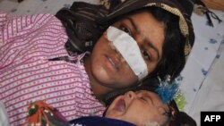 Afghan woman Reza Gul, 20, and whose nose was sliced off by her husband in an attack, lies on a bed with her baby as she receives treatment at a hospital in the northern Afghanistan on January 19. 