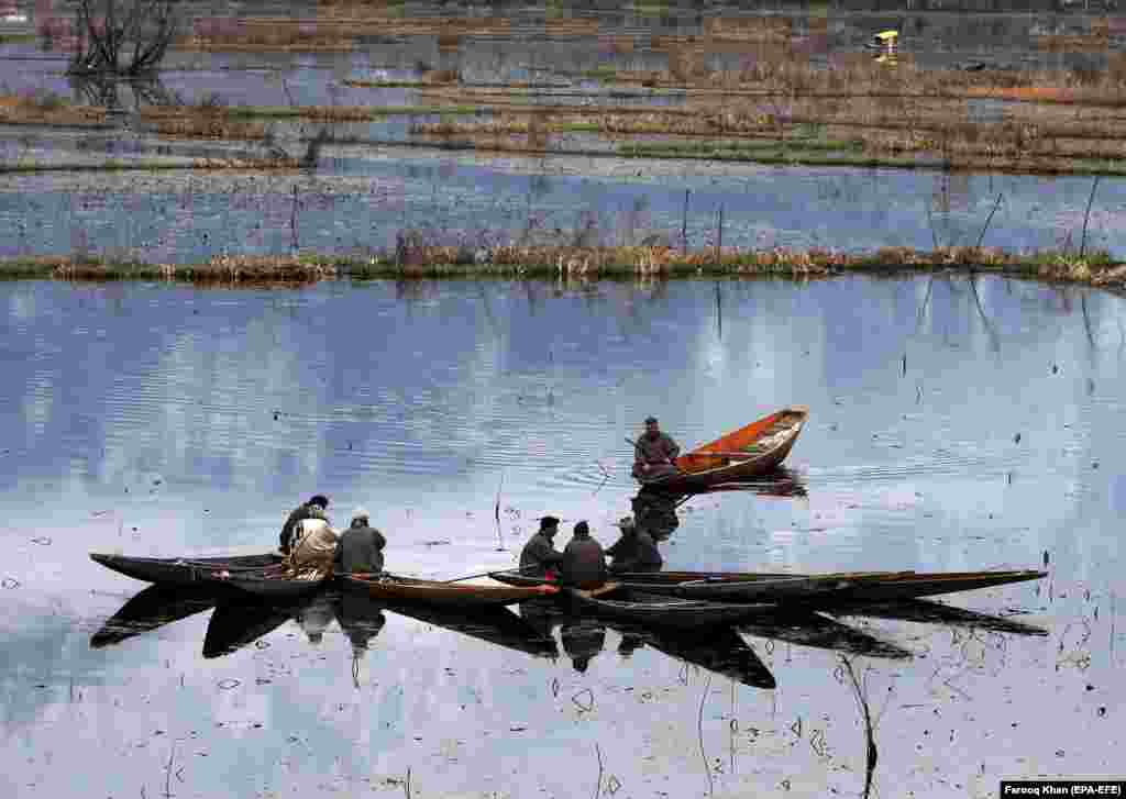 Kashmiri boatmen interact with each other as they rest on the waters of Nageen Lake in Srinagar, the summer capital of Indian Kashmir. (epa-EFE/Farooq Khan)