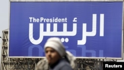 A man walks past a banner publicizing the presidential election in Cairo on April 5.