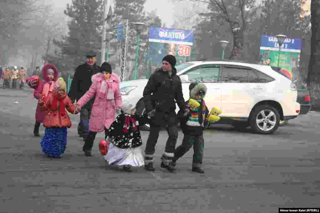 Малыши в праздничных нарядах возвращаются с новогоднего утренника. 