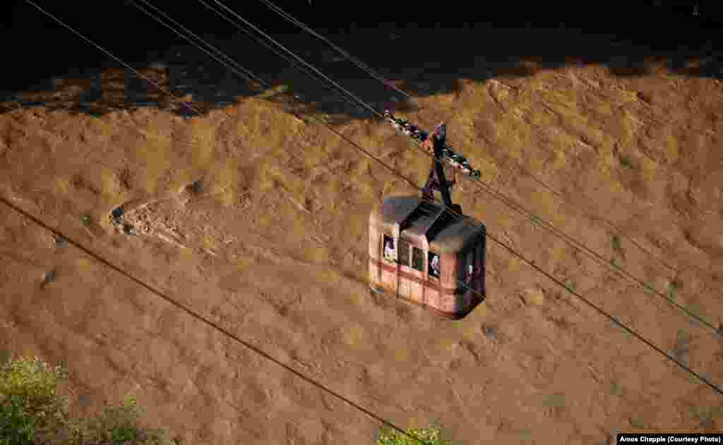 A cable car crosses over the heavily polluted Kvirila River, which runs almost black when the manganese factories are in full use.