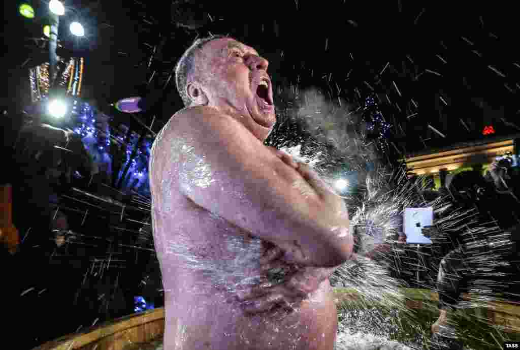 Russian Liberal Democratic Party leader Vladimir Zhirinovsky plunges into icy water during celebrations of Orthodox Epiphany in Revolution Square, Moscow. (TASS/Valery Sharifulin)