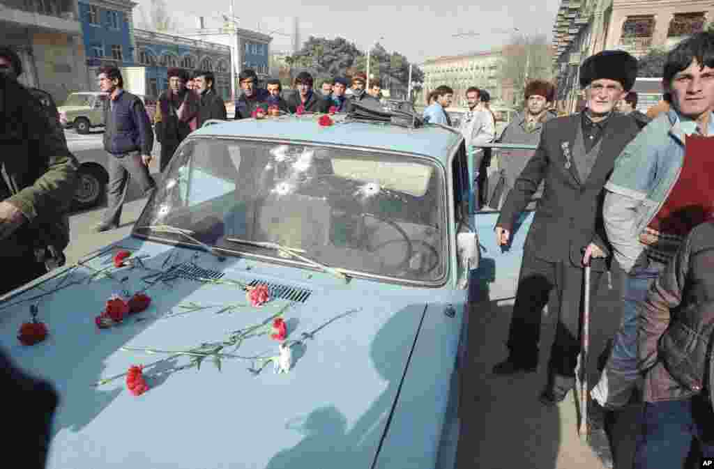 Baku residents lay flowers in honor of those who were killed in the Soviet crackdown. This car&#39;s windshield was riddled with bullet holes.