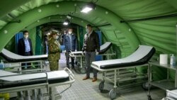 Romanian President Klaus Iohannis inspects a mobile military hospital that will tend to patients infected with the coronavirus in Otopeni, near Bucharest, on March 28.
