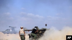 NTC fighters shoot artillery at a pro-Qaddafi position in Sirte on September 18.