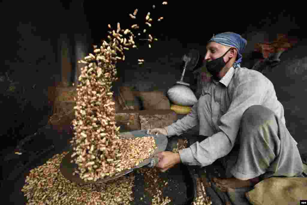 A Pakistani vendor prepares peanuts for sale on a roadside in Peshawar. (epa/Bilawal Arbab)