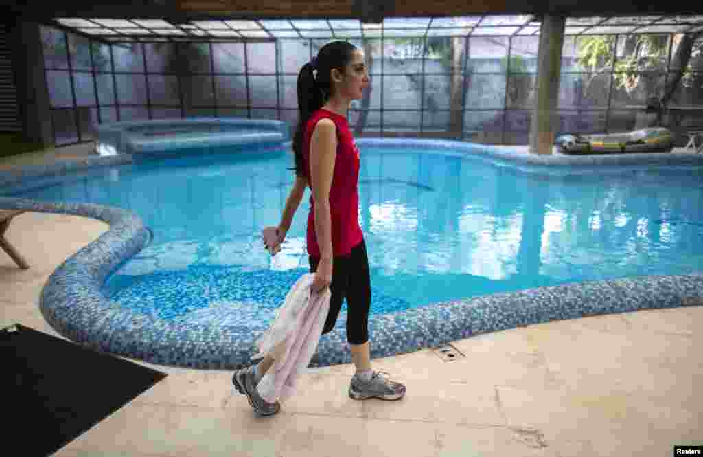 Educator and model Fatima walks past a swimming pool after working out in a gym in her home in Lahore. Fatima is the chief executive officer of the Beaconhouse School System, a network of private schools founded by her mother-in-law.
