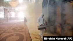 A firefighter disinfects a shrine in northern Tehran.