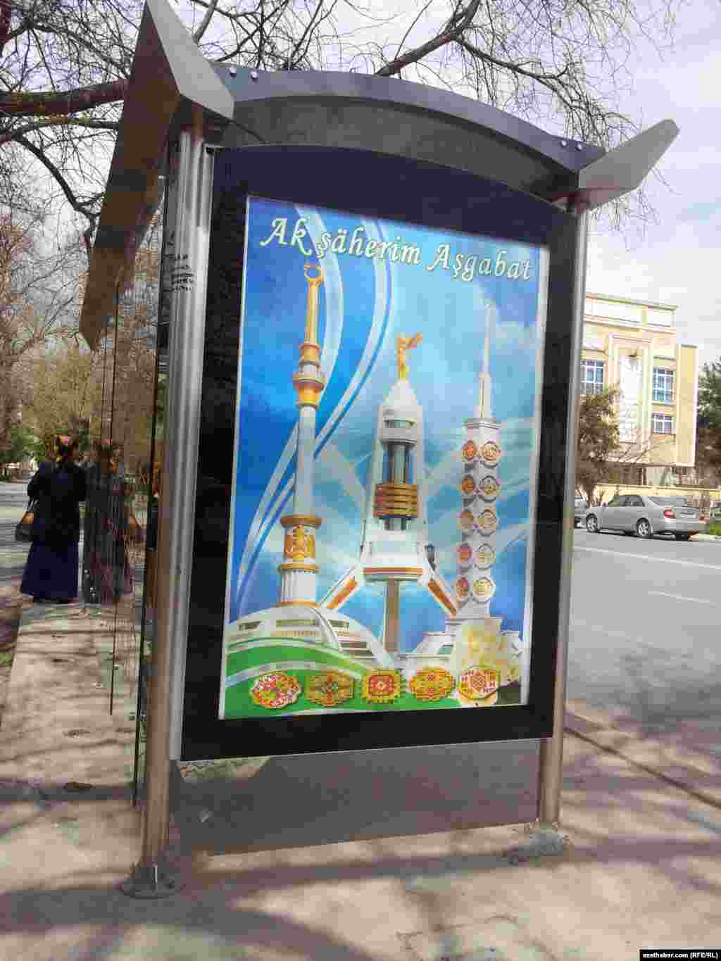Türkmen paýtagtyndaky awtobus duralgalarynyň birinde ýerleşdirilen "Ak şäherim Aşgabat" atly banner.