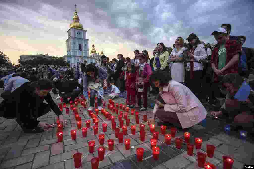 Crimean Tatars and local residents light candles during a memorial ceremony marking the 70th anniversary of the deportation of Tatars from Crimea in Kyiv on May 17. (Reuters/Konstantin Grishin)