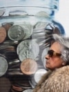 Atenta, 12 februarie 20210. O femeie trece pe lângă un poster pe care sunt trecute dobânzile pentru depozite bancare. 