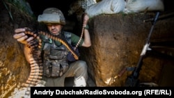 Український військовий міняє стрічку з набоями на кулеметі під час бою біля Горлівки (ілюстраційне фото)