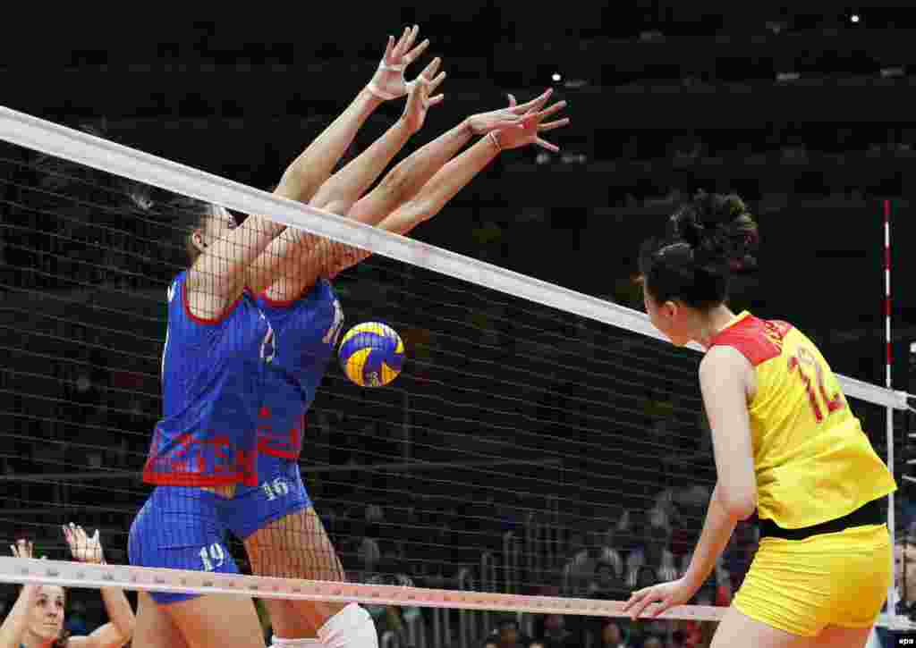 China's Ruoqi Hui (right) spikes the ball during the women's volleyball gold-medal match between China and Serbia. China won 3:1.