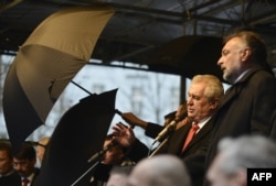 Security guards hold umbrellas in front of Milos Zeman and other European leaders as people throw eggs and other objects at the Czech president before the Prague unveiling of a plaque on the 25th anniversary of the Velvet Revolution on November 17.