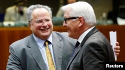 Greek Foreign Minister Nikos Kotzias (left) and his German counterpart, Frank-Walter Steinmeier, attend the extraordinary European Union foreign ministers meeting in Brussels on January 29.