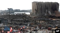 People gather on August 11 in honor of the victims at the scene of the explosion that devastated in Beirut the week before.