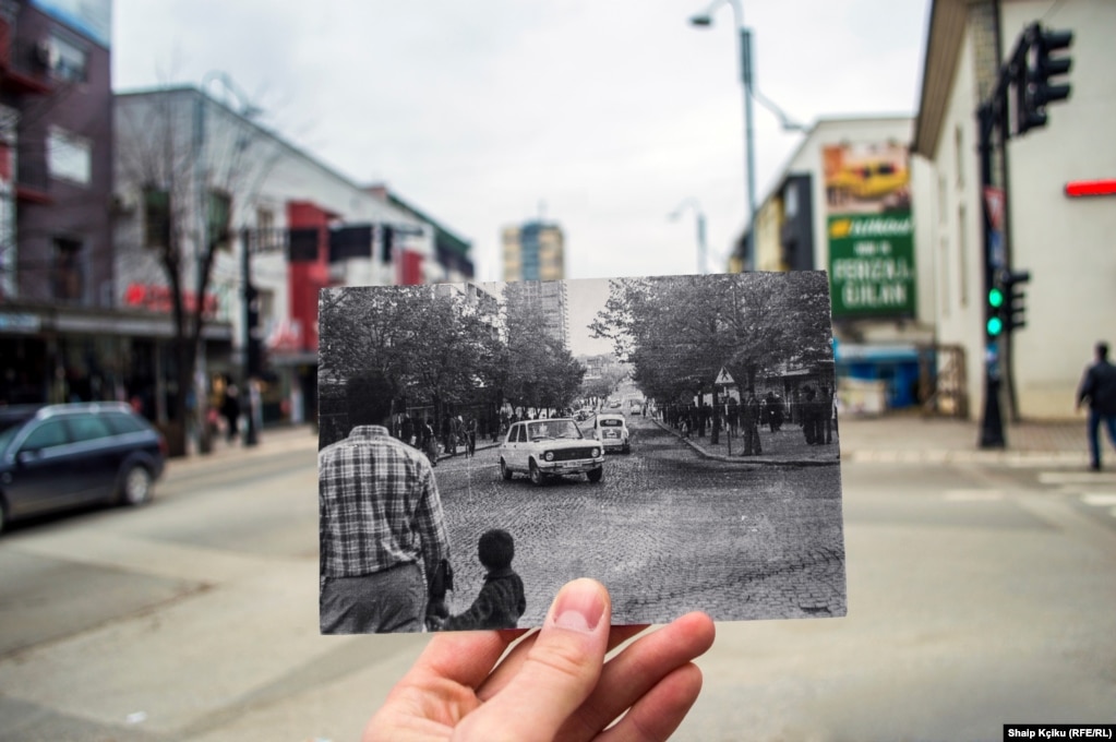 Shaip Kçiku got out of bed extra early that day. He told RFE/RL, "I wanted to make sure the streets were empty to take the photo." The print he's holding shows the Gjilan neighborhood as it looked in the 1970s.