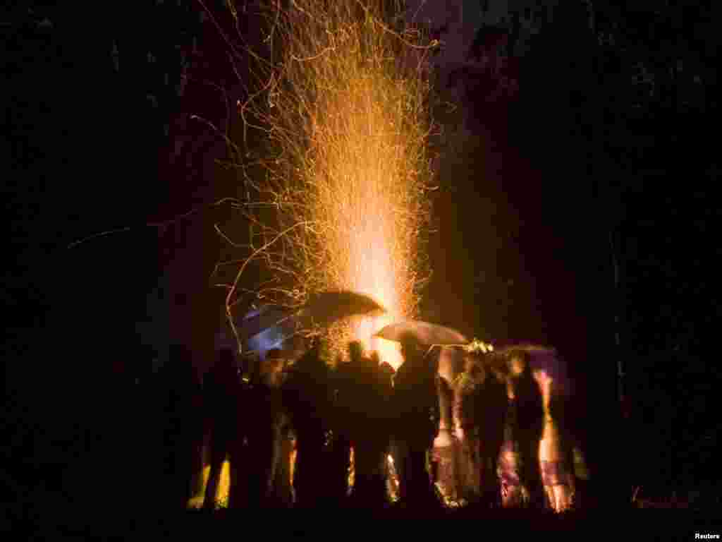 People stand around a campfire during the Ivana Kupala festival in the village of Viazynka, northwest of Minsk, on June 22. The ancient tradition, originating from pagan times, is usually marked with grand overnight festivities that includes jumping over burning campfires and bathing in a lake or a river, as people believe that will purge them of their sins and make them healthier. (Photo by Vladimir Nikolsky/Reuters)