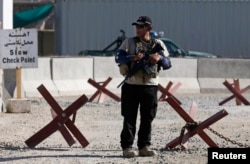 A foreign security contractor keeps watch at the site of a blast near the Kabul International Airport, July 22, 2014