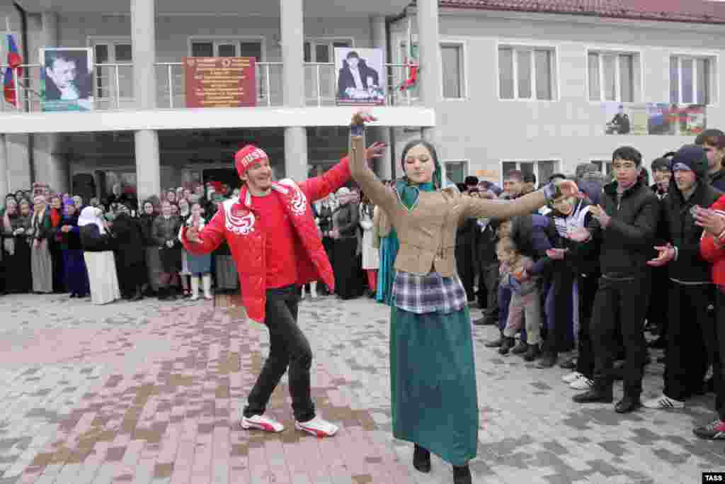 A young man and woman dance outside a polling station in Grozny during Russia&#39;s presidential election in March 2012.