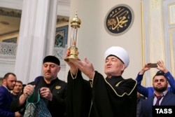 Председатель совета муфтиев России Равиль Гайнутдин со стеклянной капсулой с волосом пророка Мухаммеда, подаренным главой Чечни Рамзаном Кадыровым, в главной мечети России. 6 октября 2015 года