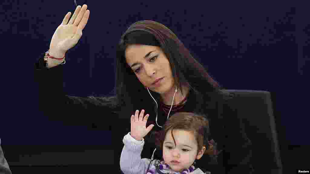 Licia Ronzulli, an Italian member of the European Parliament, takes part with her daughter in a voting session at the European Parliament in Strasbourg. (Reuters/Vincent Kessler)